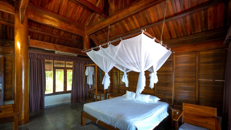 A cozy bedroom with wooden decor and a white canopy bed, offering a retreat in nature., tags: oude je - pexel