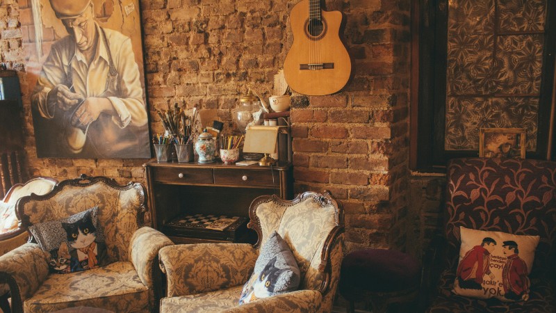 Warm vintage room with armchairs, guitar, and artwork on a brick wall, creating a cozy atmosphere., tags: het kiezen van de bekledingsstof je - pexel