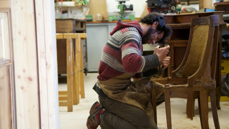 Skilled craftsman restoring an antique wooden chair in a workshop, focused on detailing., tags: het - pexel